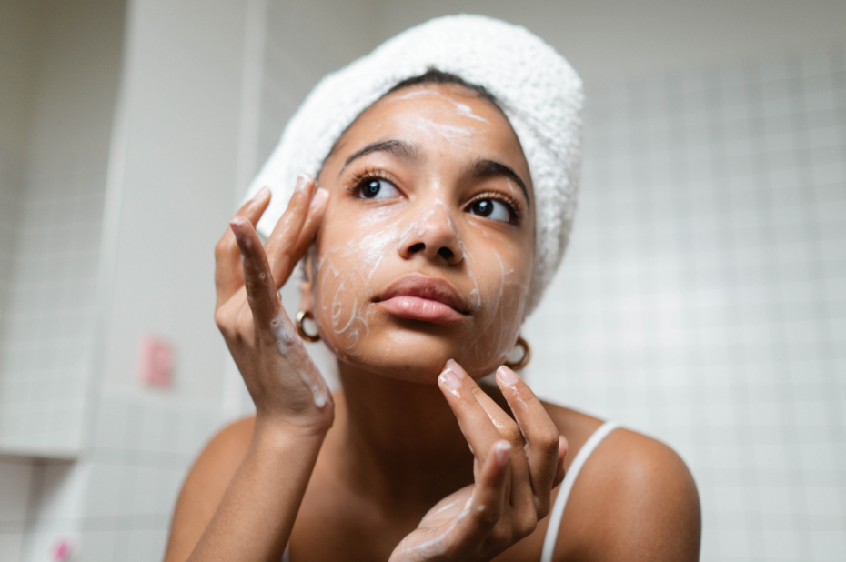 Young woman carefully cleansing face.