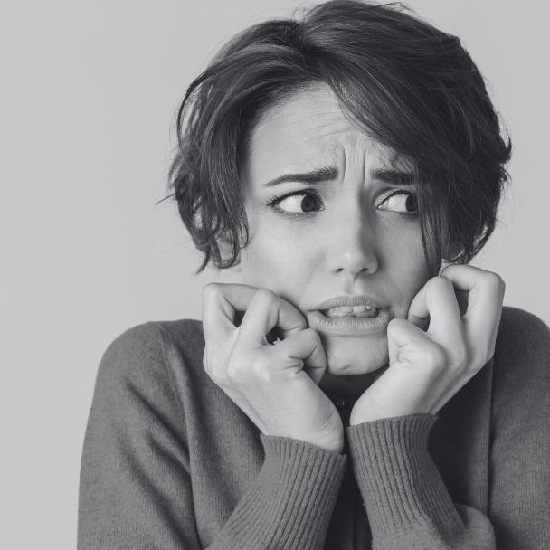 Black and White image of woman looking scared.