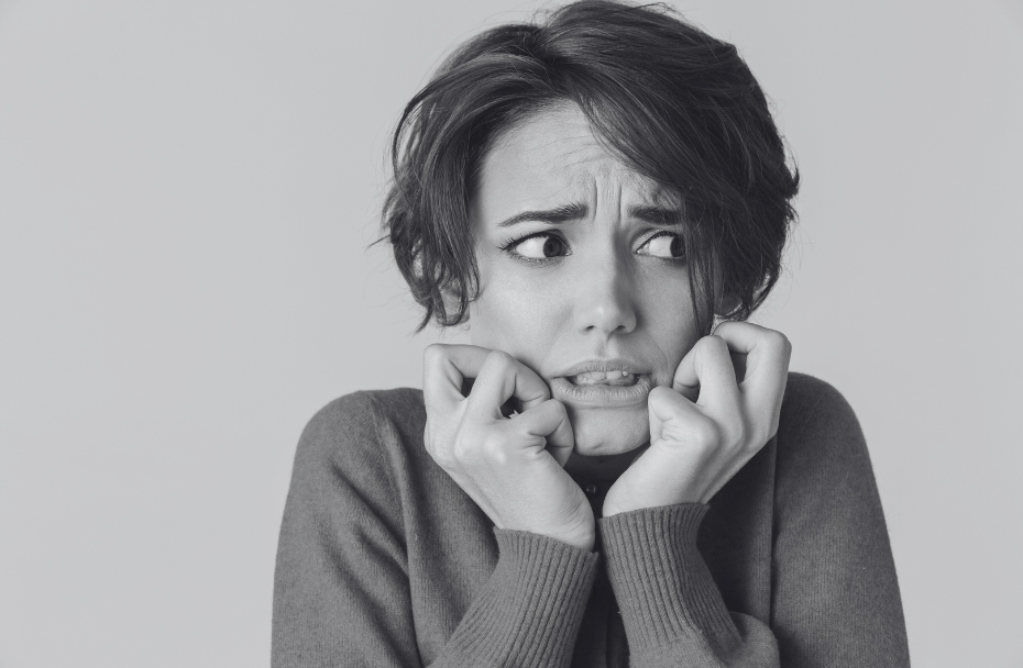 Black and White image of woman looking scared.