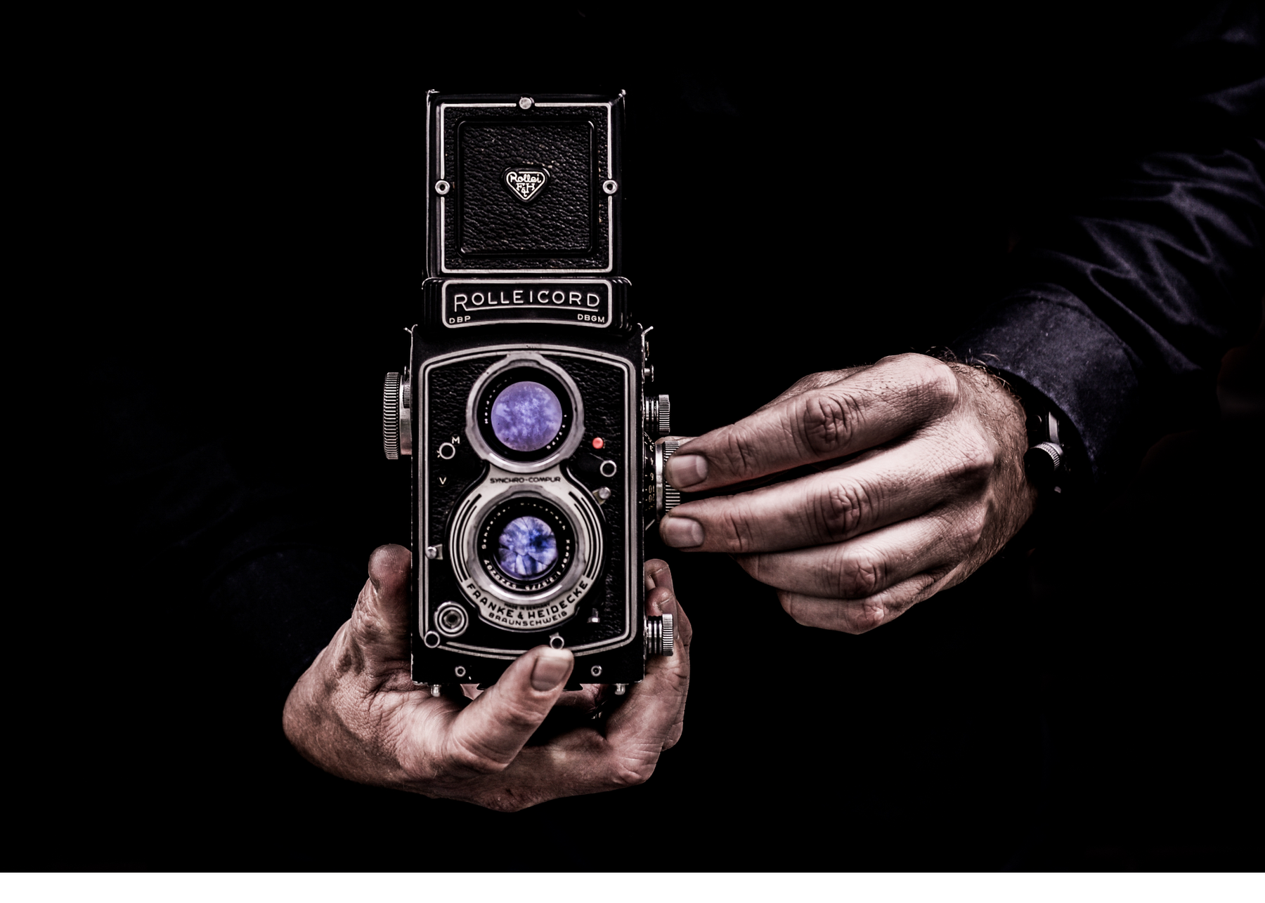 The hands of a black man holding a camera