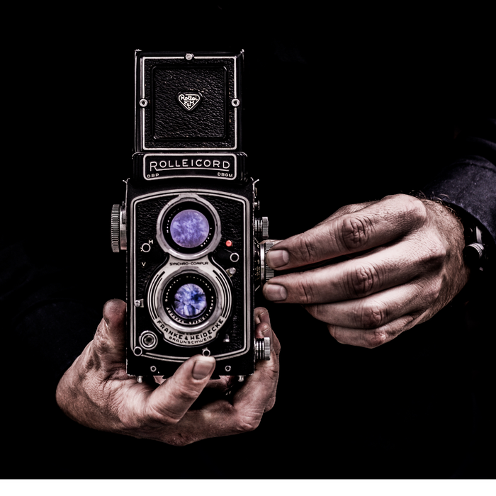 The hands of a black man holding a camera