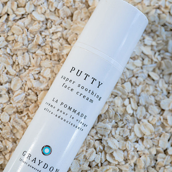 A soothing moisturizer for dry skin in white packaging on a bed of oats