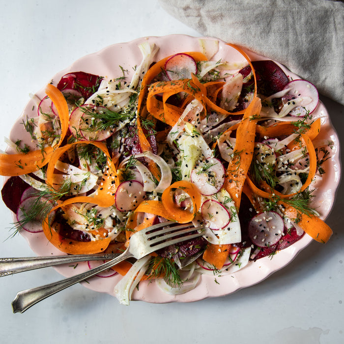 Fennel and root vegetable salad with Za’atar vinaigrette on a light pink serving platter